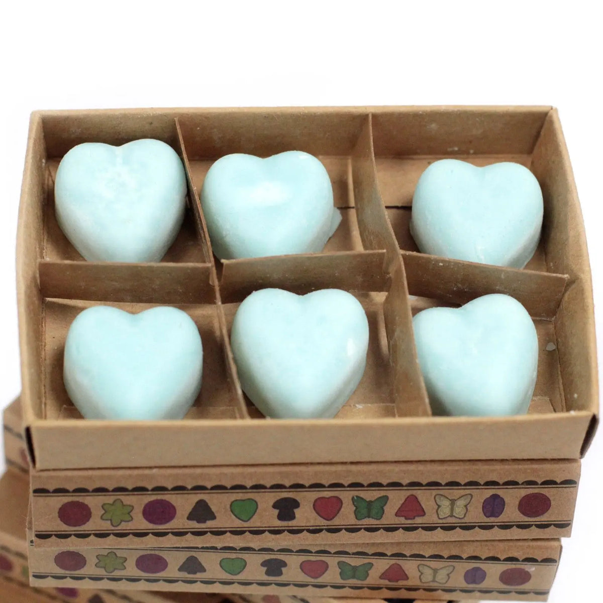 Caja de cartón con 6 ceras de soja en forma de corazón color azul claro, decorada con motivos geométricos y naturales.