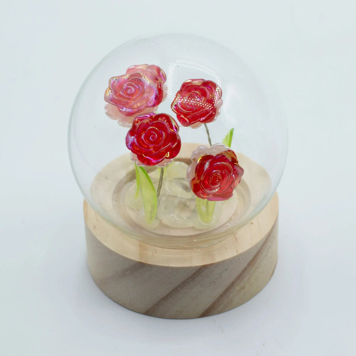Domo de cristal con 4 rosas rojas brillantes sobre base de madera, con iluminación LED de Ancient Wisdom.