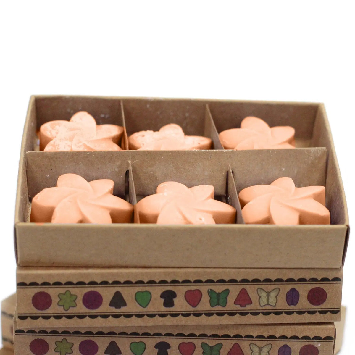 Caja de cartón con 6 piezas de cera de soja color melocotón en forma de flor. Diseño rústico con cenefa decorativa.