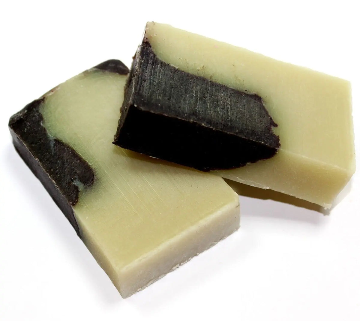 Dos bloques rectangulares de jabón artesanal bicolor, con tonos crema y marrón oscuro, sobre fondo blanco.