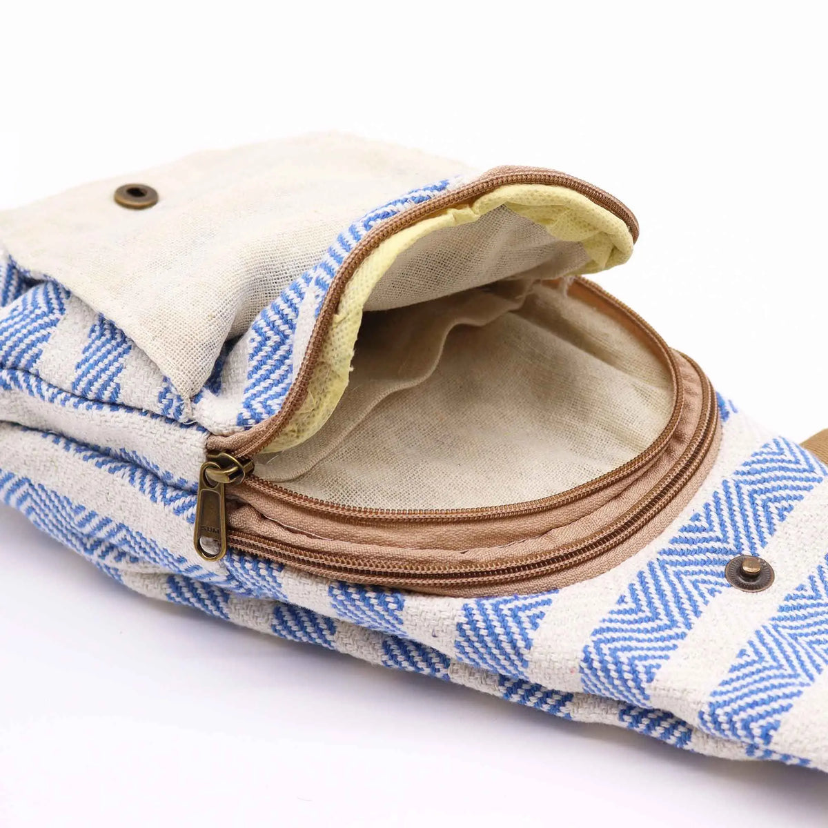 Bolso bandolera de algodón con estampado geométrico azul y blanco, cierre de cremallera y solapa con botón metálico.