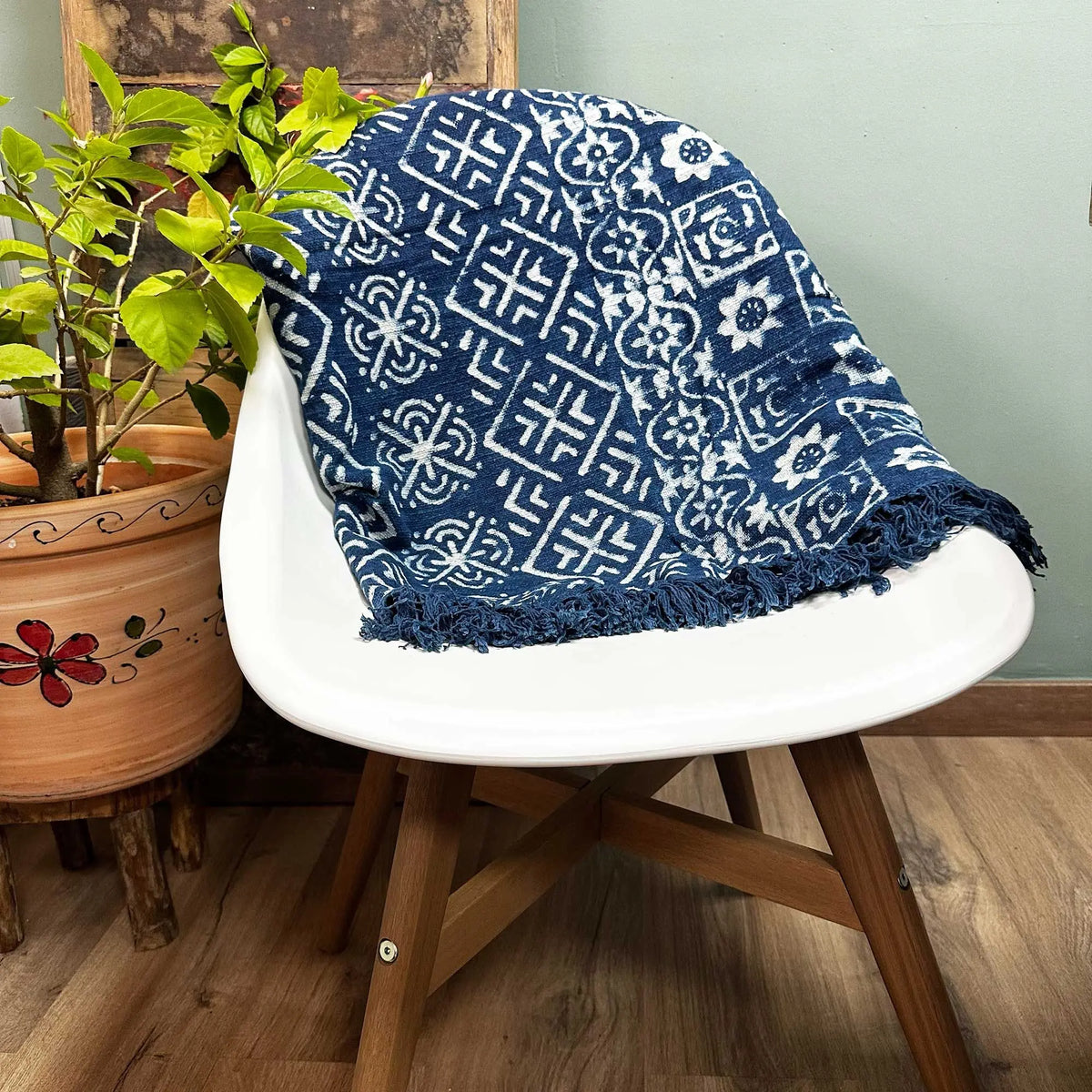 Manta azul marino con diseño geométrico blanco y flecos, ideal para decoración y confort.