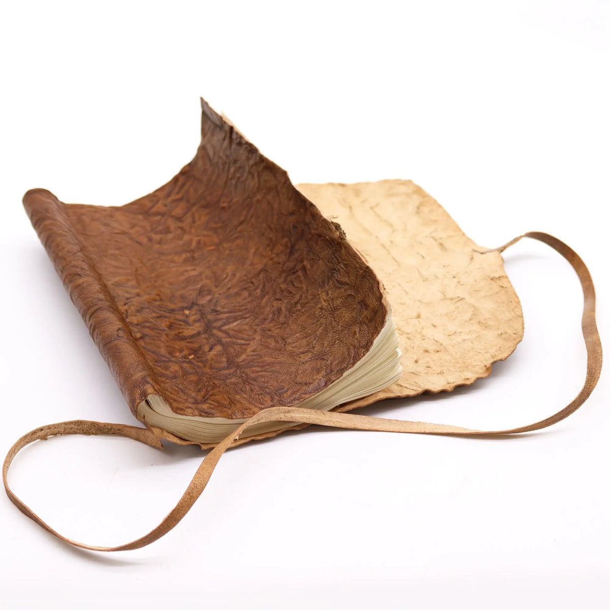 Cuaderno de cuero marrón con papel crudo, diseño rústico y tapa de textura arrugada. Ideal para notas y bocetos.