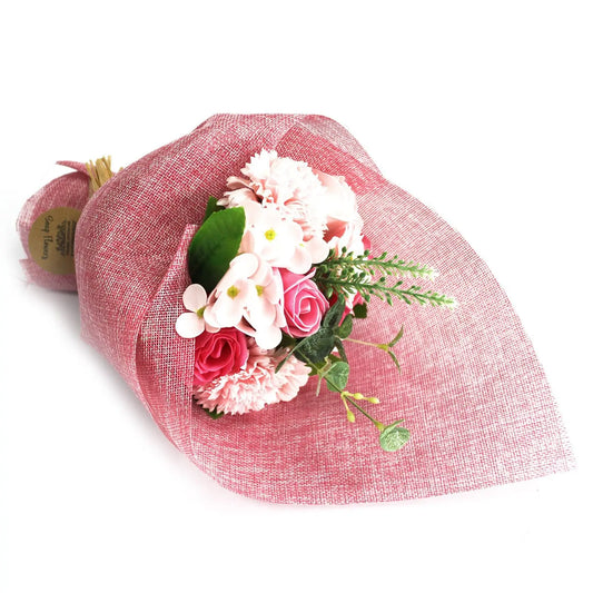 Ramo de flores de jabón en tonos rosa y blanco envuelto en papel de tela rústico de color rojizo con un estilo elegante