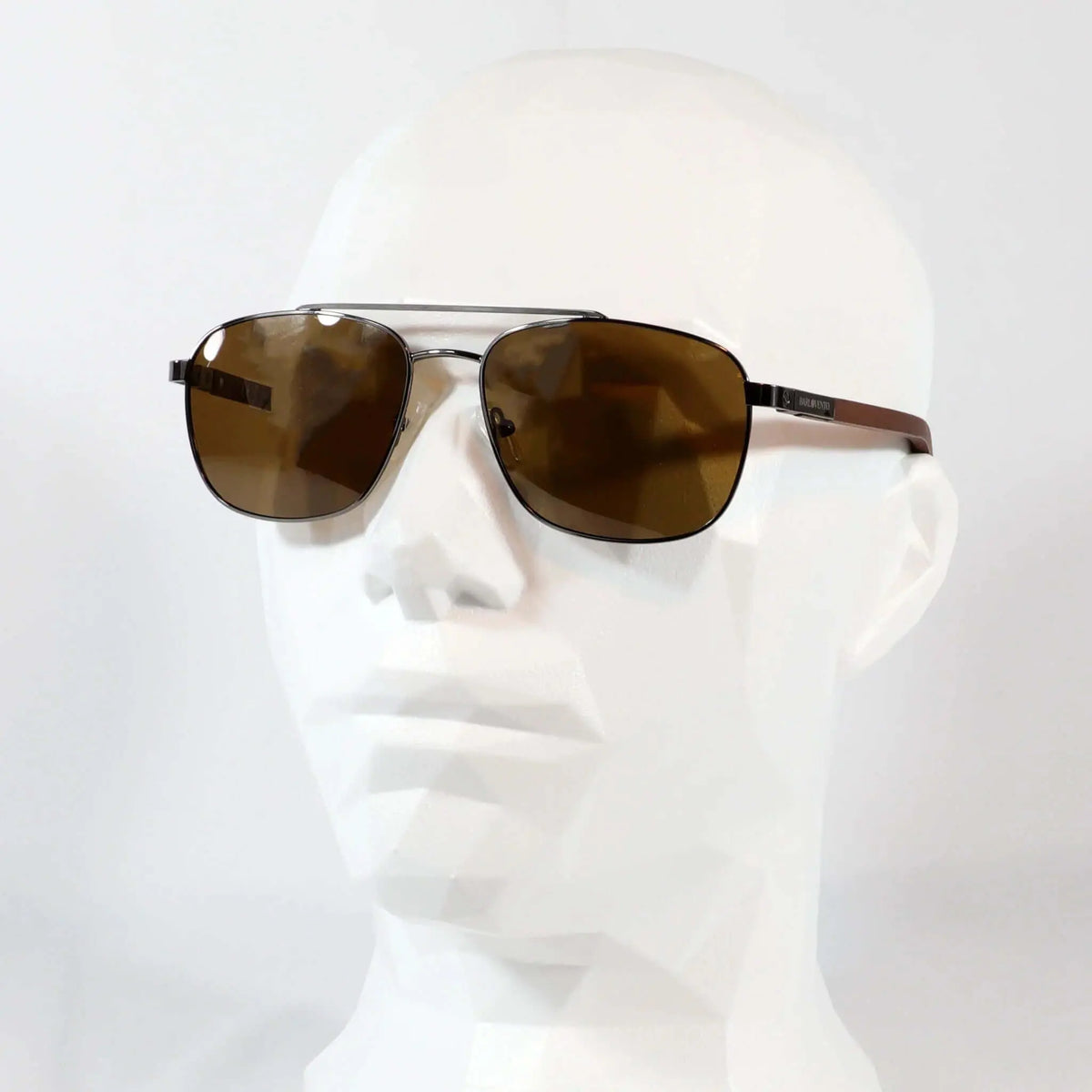 Gafas de sol tipo aviador con montura metálica oscura, lentes marrones y patillas de madera sobre maniquí blanco.
