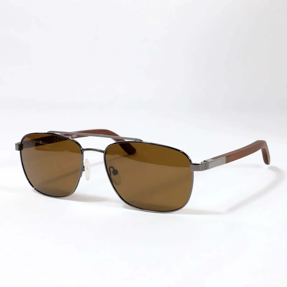 Gafas de sol estilo aviador con montura metálica gris, lentes marrones y patillas de madera sobre fondo blanco.