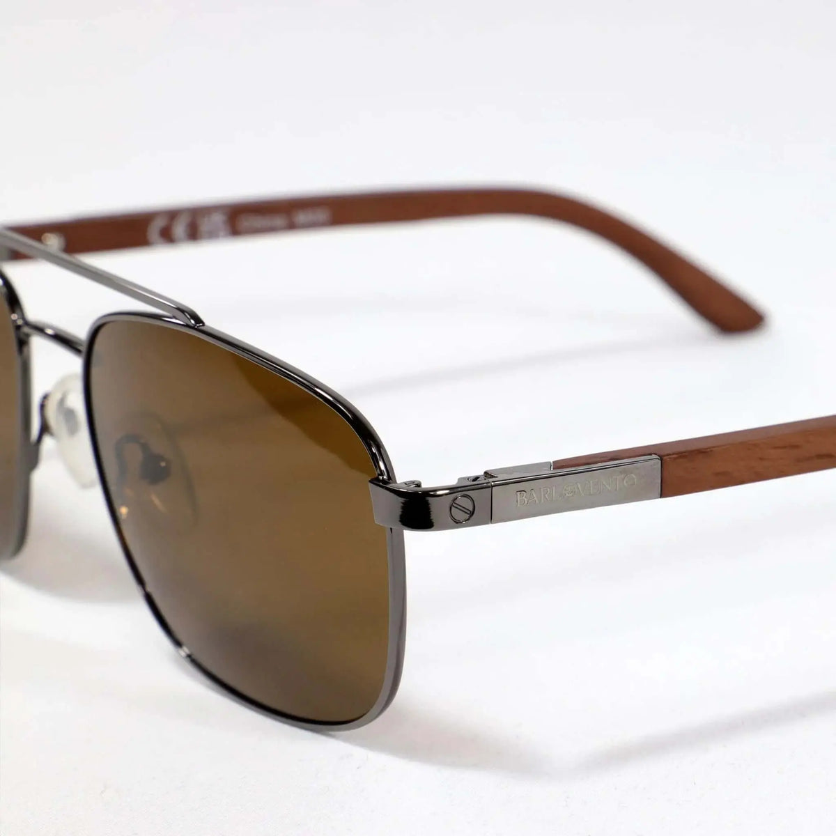 Gafas de sol estilo aviador con montura metálica oscura, cristales marrones y patillas de madera natural.