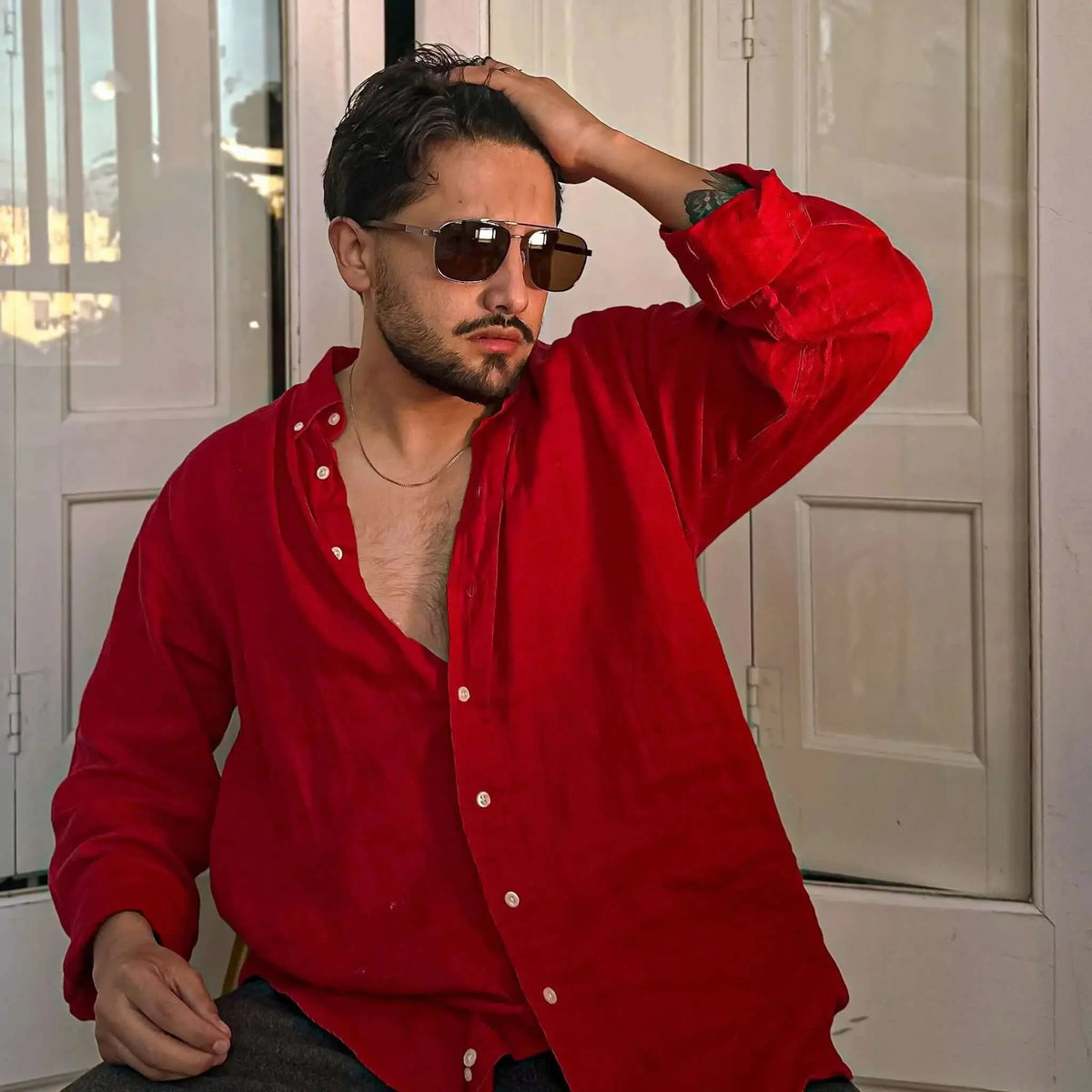 Gafas de sol estilo aviador con montura metálica y patillas de madera, lentes oscuras de tono marrón.