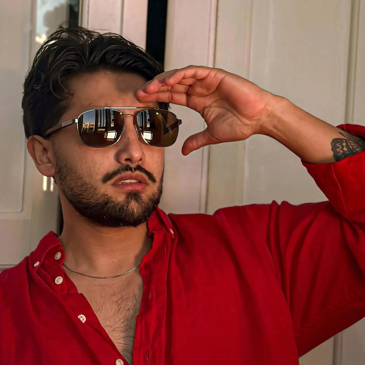 Gafas de sol estilo aviador con marco metálico plateado y patillas de madera oscura, lentes reflectantes.