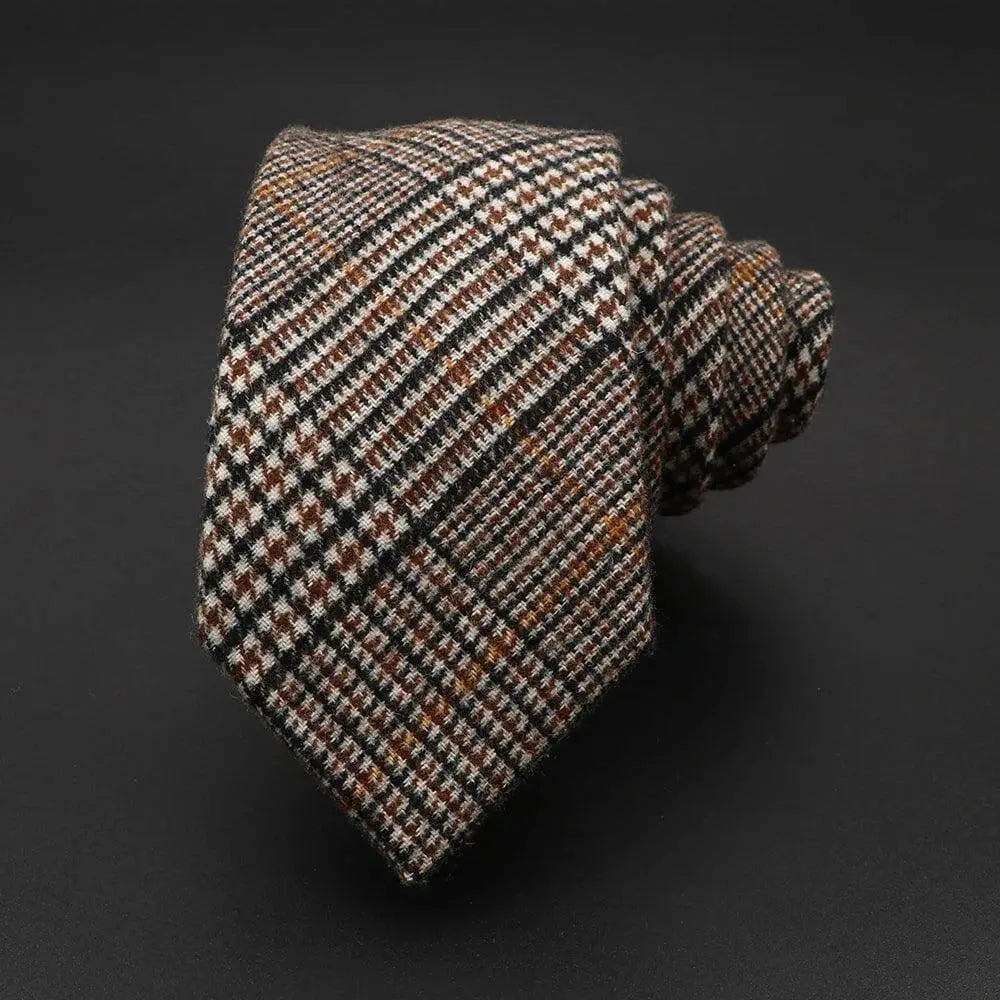 Corbata de lana enrollada con estampado de cuadros príncipe de Gales en tonos marrones, negros y blancos.