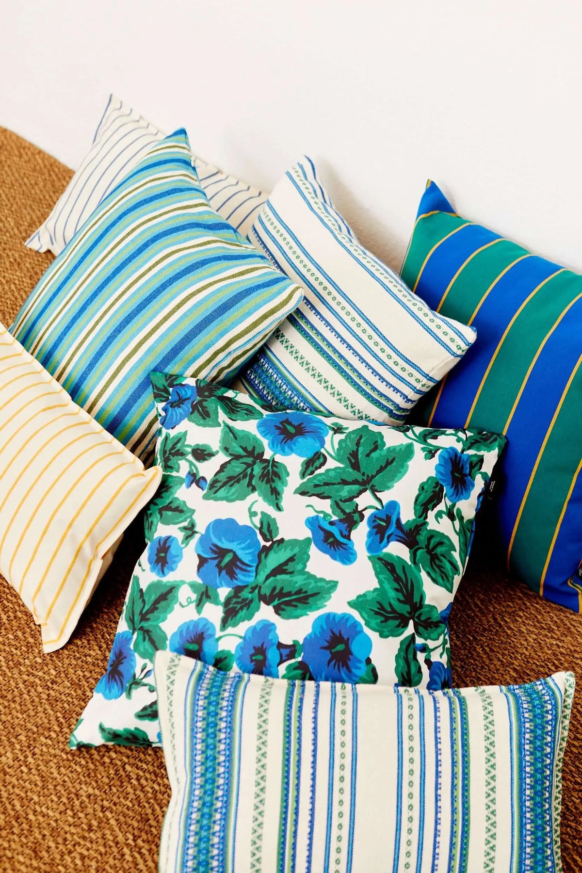 Conjunto de fundas de cojín de lona de 50x50cm con estampados de rayas y flores en tonos azules, verdes y amarillos.