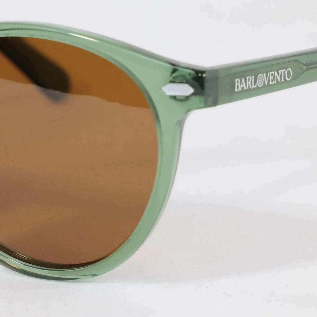 Gafas de sol de estilo redondo con montura de acetato verde traslúcido y lentes en tono marrón.