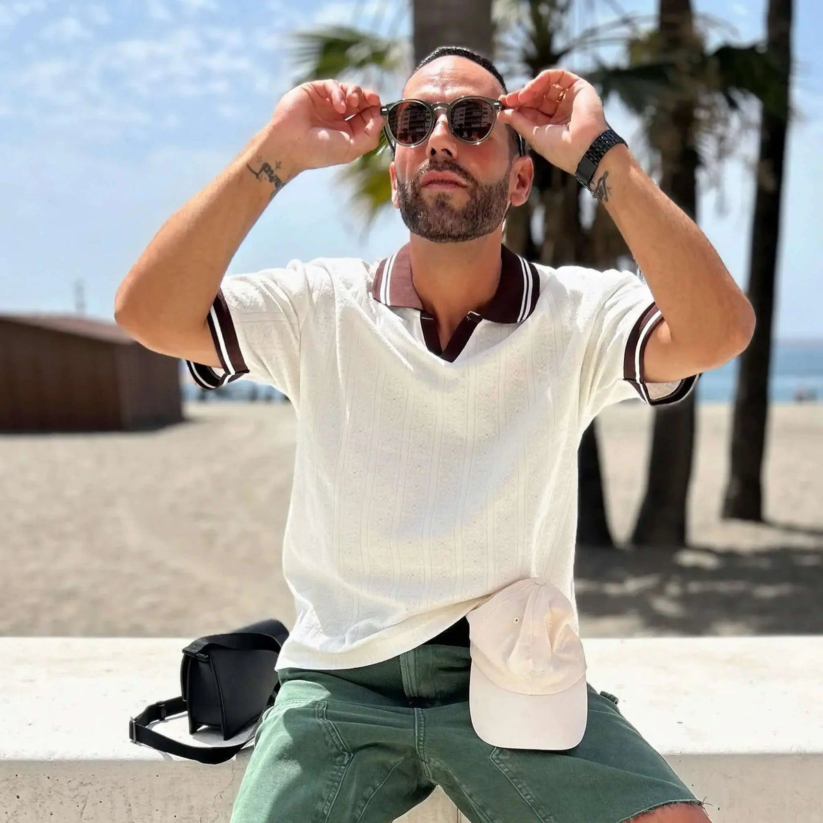 Gafas de sol redondas con montura verde translúcida y lentes marrones, estilo casual en la playa.