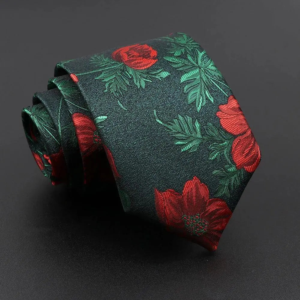Corbata de tela oscura con estampado floral en tonos rojos y hojas verdes sobre fondo negro. Estilo elegante.