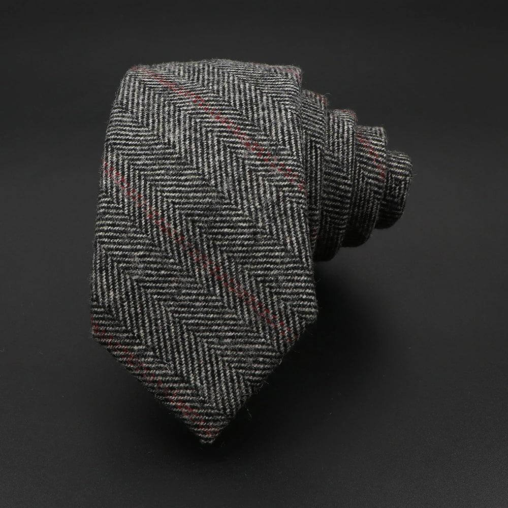 Corbata de Lana Gris Canadá Estrecha 6.5cm con patrón de espiga y detalles en rojo sobre fondo negro.