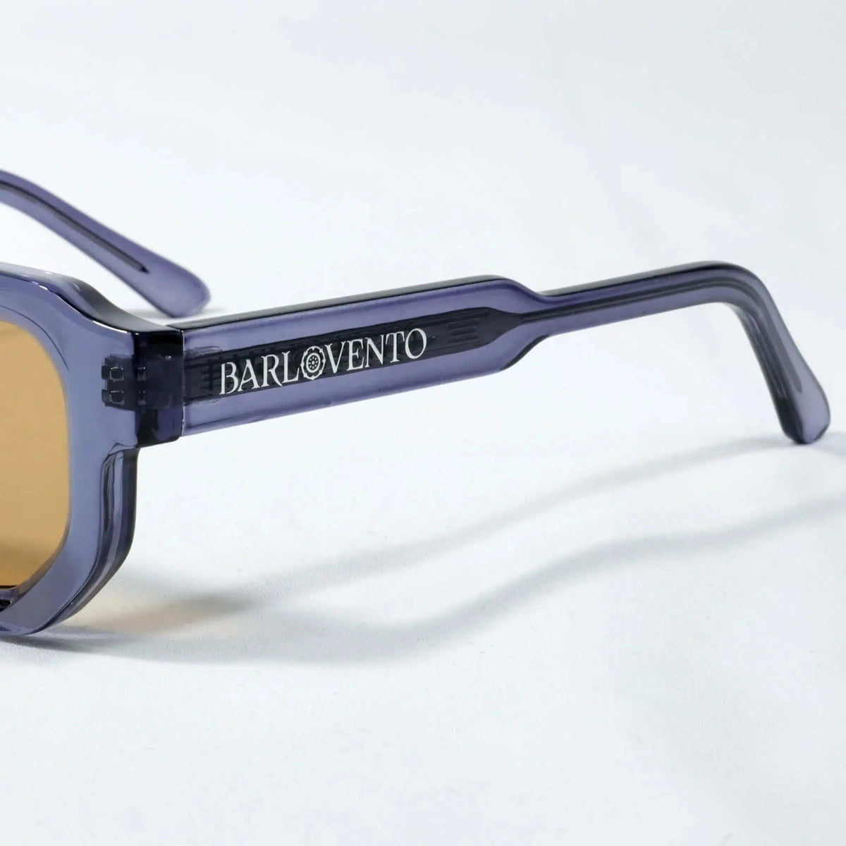 Gafas de sol de pasta azul traslúcido con diseño geométrico y cristales en tono marrón, estilo moderno.