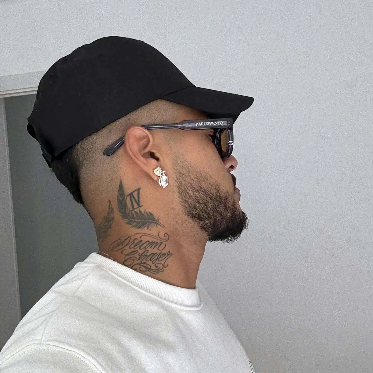Gafas de sol de montura azul oscuro y cristales marrones de estilo rectangular, puestas de perfil sobre un hombre.
