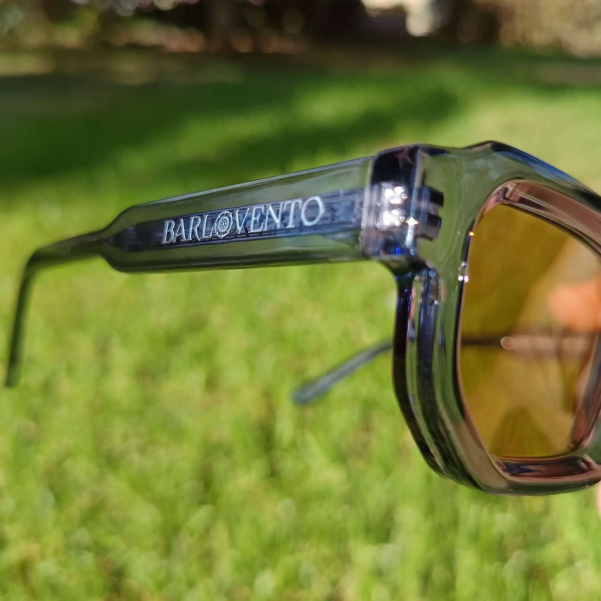 Gafas de sol con montura de acetato azul translúcido y lentes marrón ámbar, diseño robusto de estilo moderno.