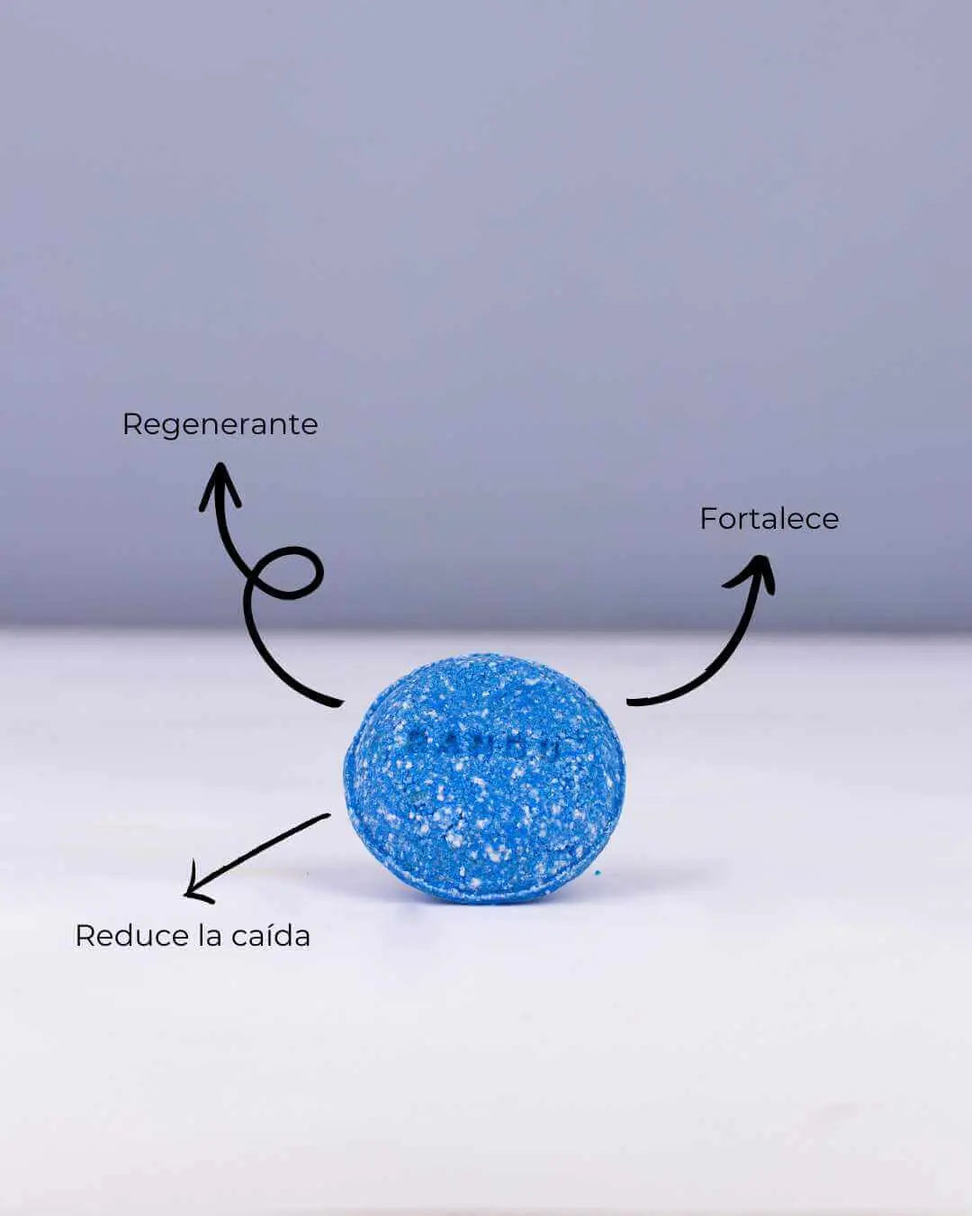 Champú sólido Banbu azul, texturizado, con flechas que indican sus beneficios: regenerante, fortalece y reduce la caída.