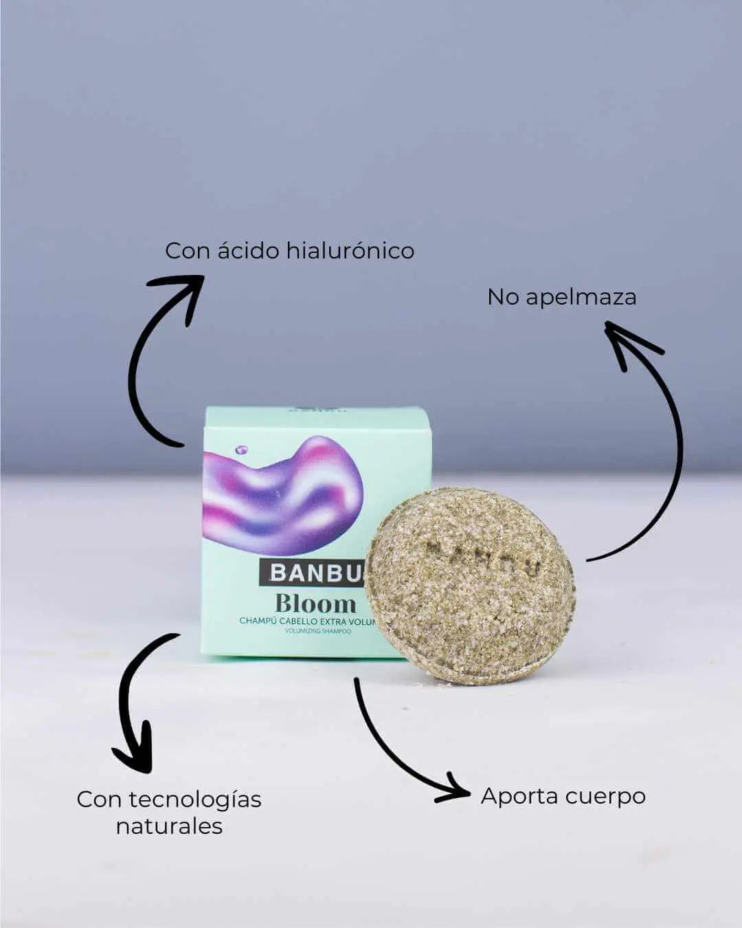 Champú sólido Banbu Bloom para volumen, junto a su caja verde menta, con flechas indicando sus beneficios naturales.