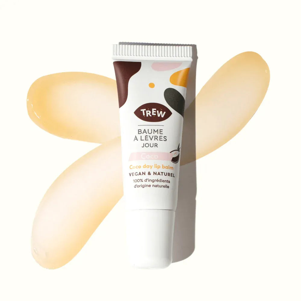 Tube de baume à lèvres Trew coco sur fond blanc, entouré de deux touches de texture baume translucide et dorée.