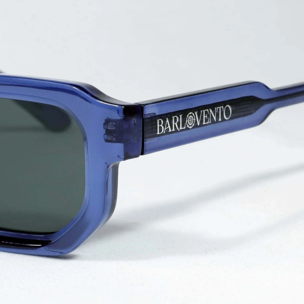 Gafas de sol de montura rectangular de acetato translúcido en color azul intenso con lentes oscuras.