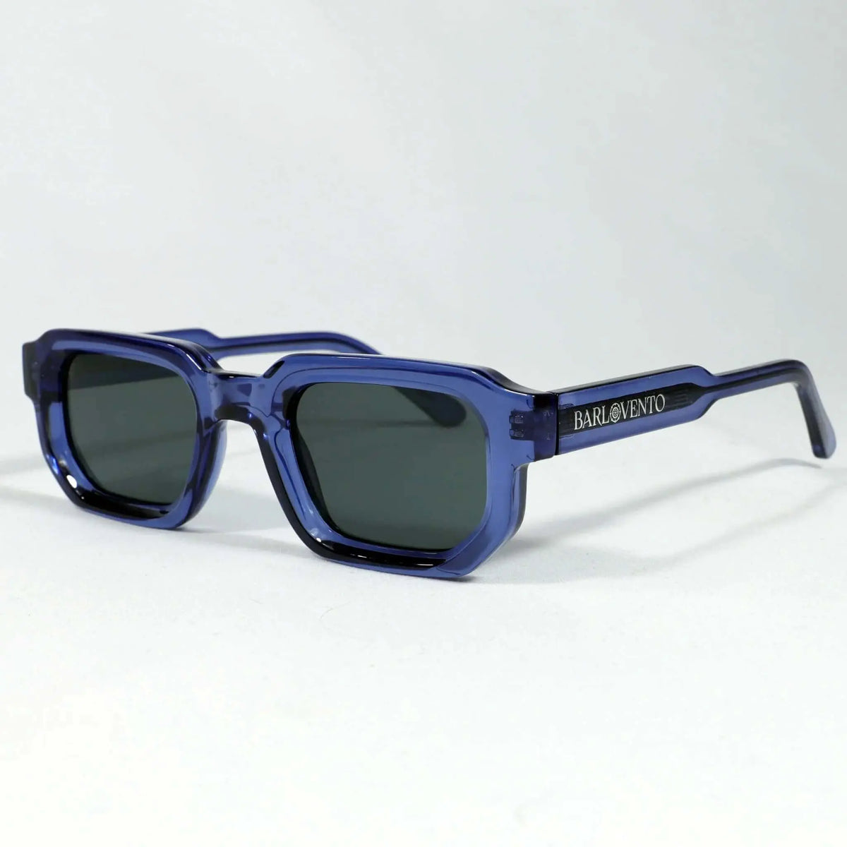 Gafas de sol rectangulares con montura de acetato azul traslúcido y lentes oscuras, diseño moderno y definido.