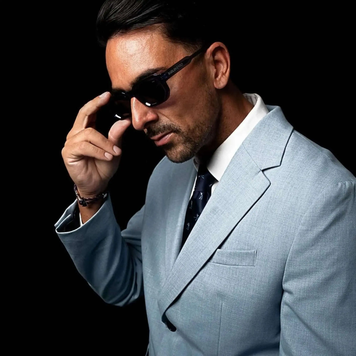 Hombre con americana azul claro y corbata azul marino con estampado de golfistas en un estilo elegante y profesional.