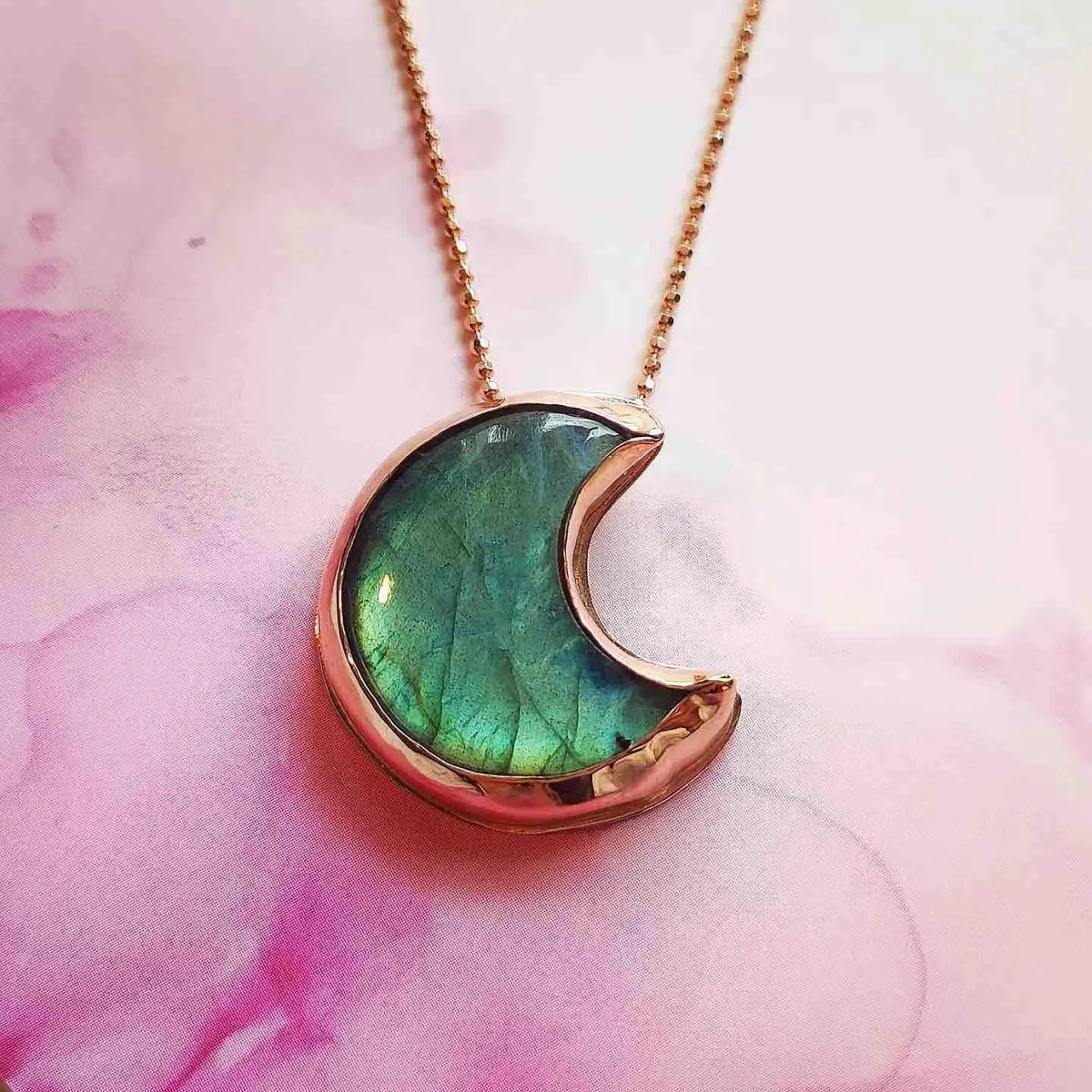Collar con colgante en forma de luna, color verde y dorado, hecho de resina y metal. Ideal para un look moderno.