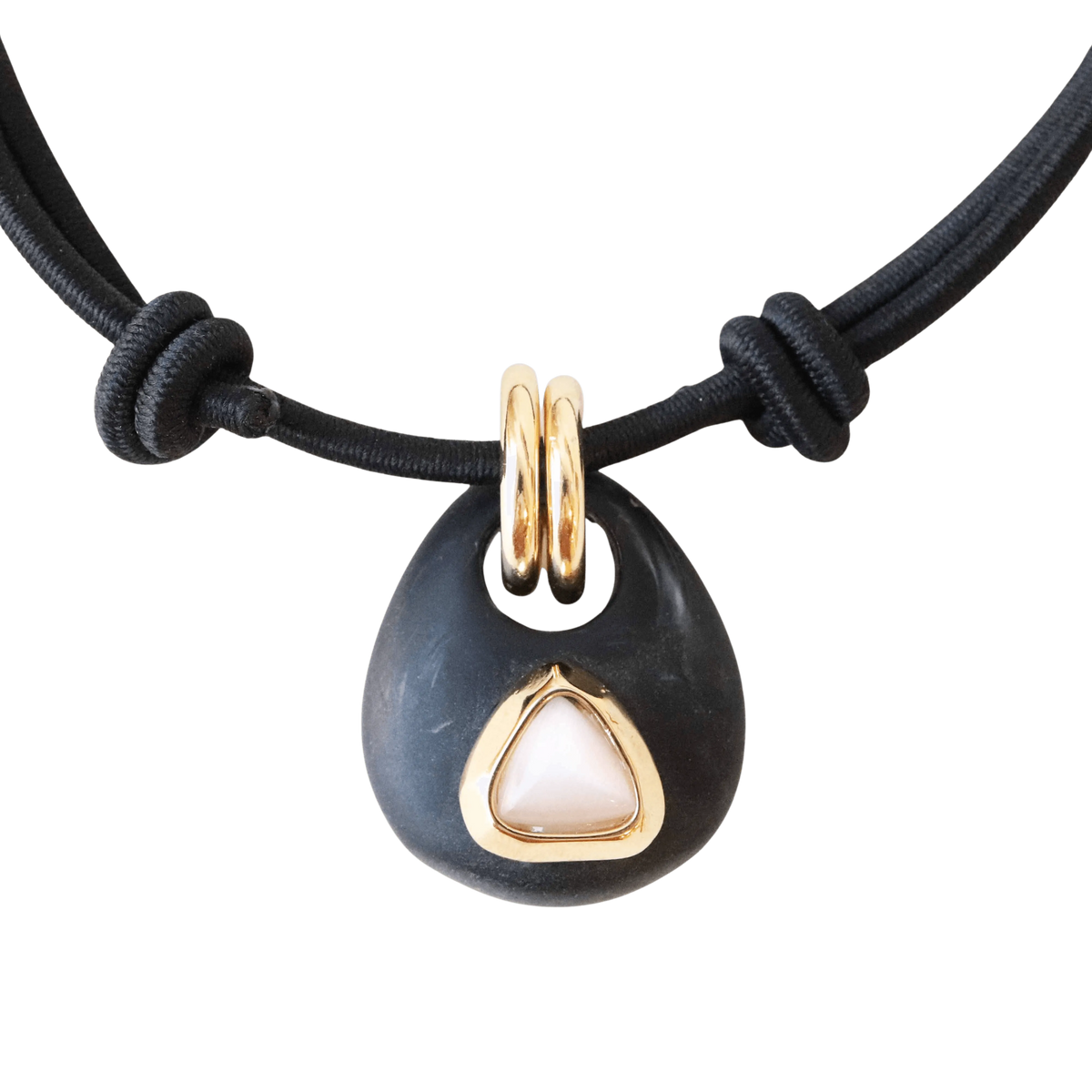 Collar de goma negra con dorado y piedra rosa en forma de triángulo, estilo moderno y elegante.