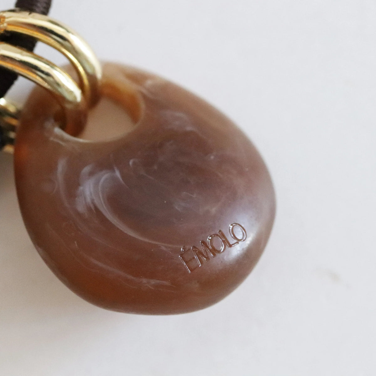 Colgante de ágata marrón con dorados, estilo moderno y elegante, ideal para un toque sofisticado en cualquier atuendo.