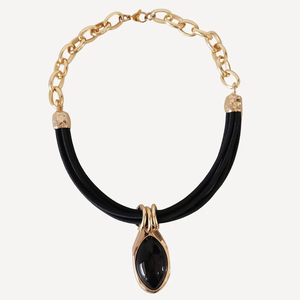Collar de cadena dorada con detalle de ónice negro y cordón de goma negro, estilo moderno y elegante.