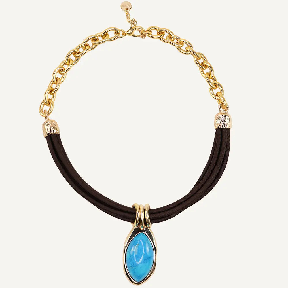 Collar de cadena dorada con detalle azul en forma de lágrima y cordón negro. Estilo moderno y elegante.