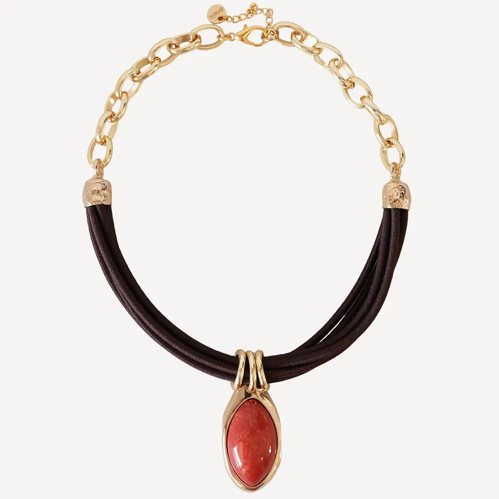 Collar de cuero marrón con detalle en piedra roja y cadena dorada, estilo elegante y moderno.