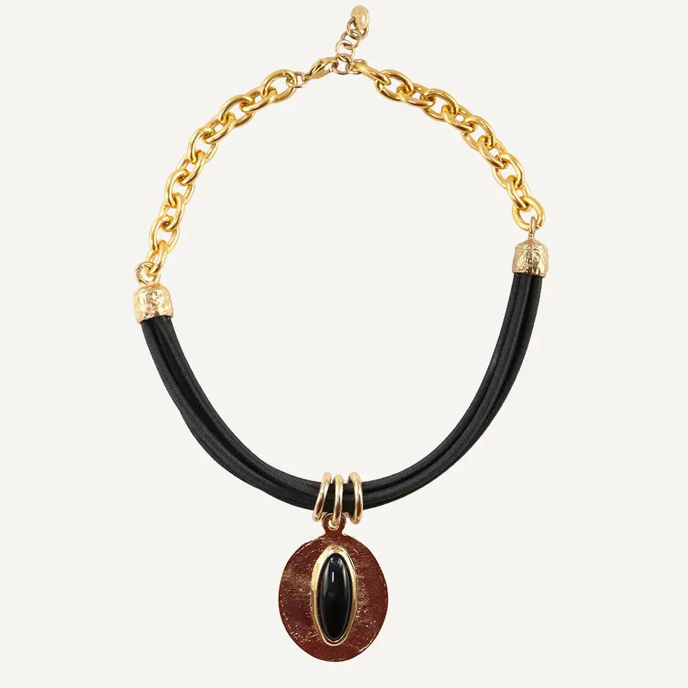 Collar moderno de cadena dorada, cuero negro y colgante ovalado rojo con gema negra.