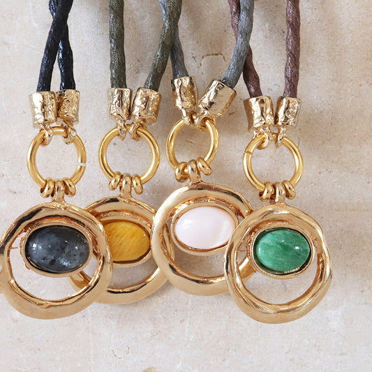 Collares de cadena de cuero con colgantes dorados y piedras naturales en colores verde, rosa, gris y amarillo.