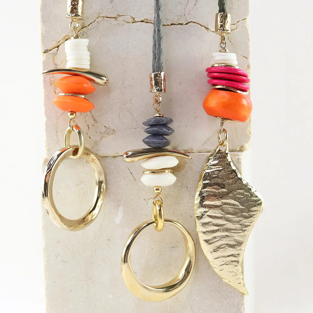 Collar bohemio con pomos de cerámica naranja, rosa y gris, y detalles en metal dorado.