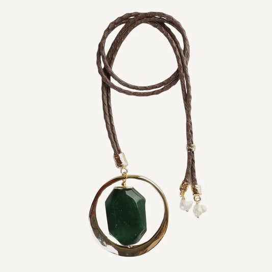 Collar de cordón café con colgante de piedra verde y detalles dorados, elegante y moderno.