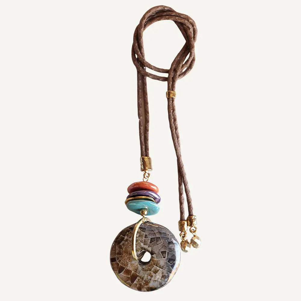 Collar de piedras naturales, cordón marrón, elementos multicolor, detalle dorado y estilo bohemio.
