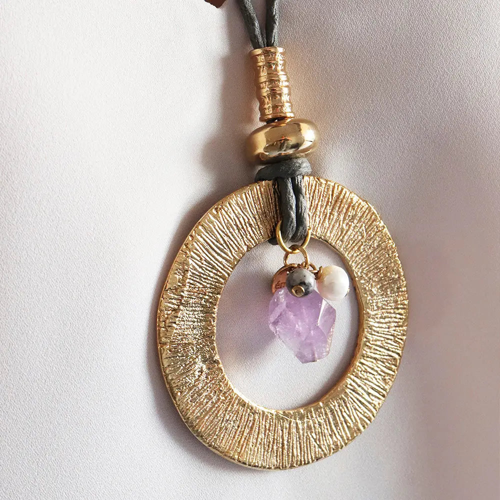 Collar de oro con colgante ovalado, cristal de amatista y perla, estilo bohemio y elegante.