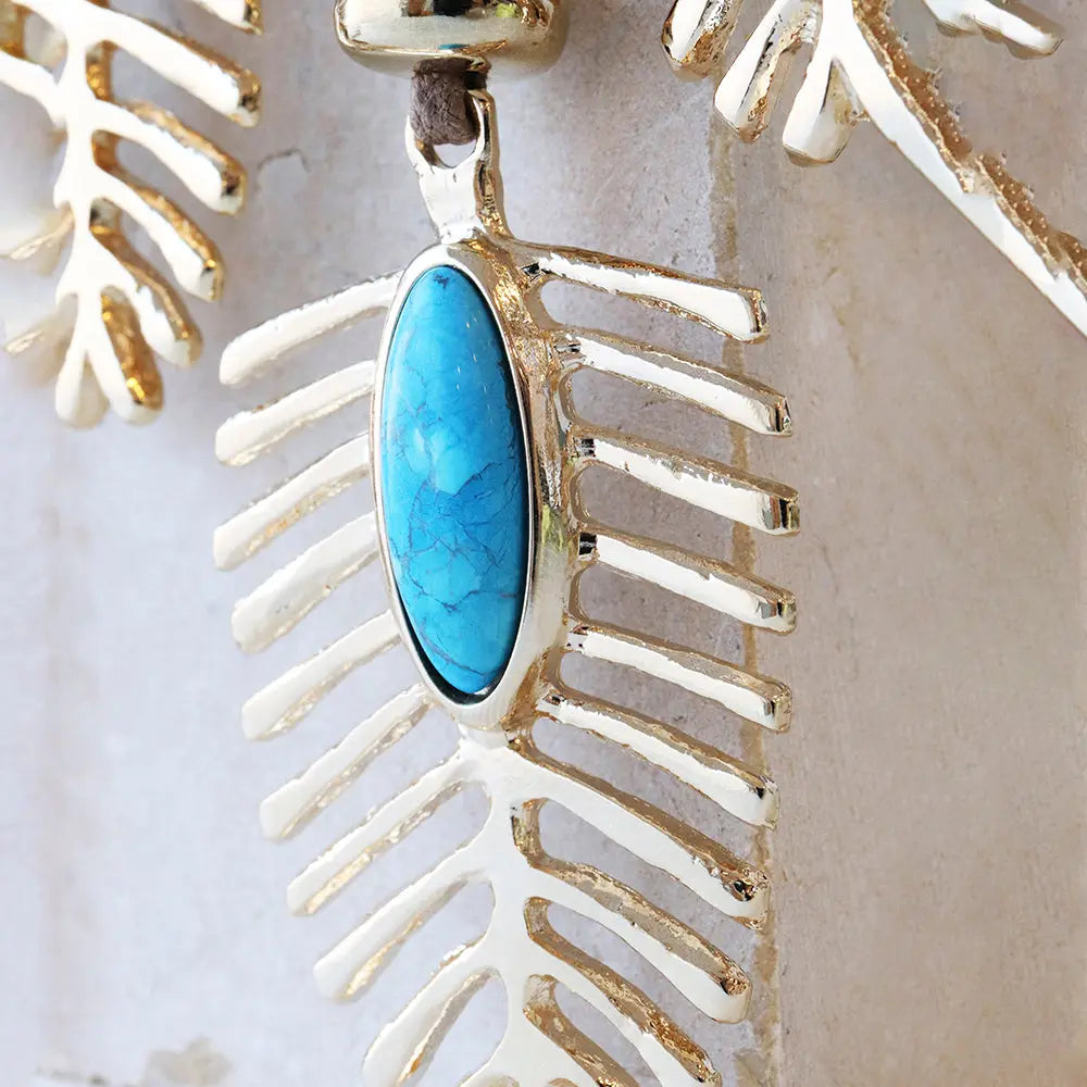 Pendiente de plata con diseño de hoja y piedra turquesa ovalada. Ideal para un estilo contemporáneo y elegante.