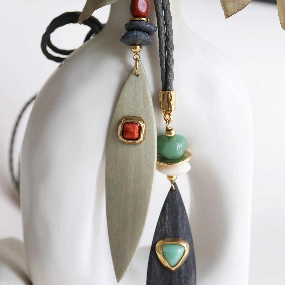 Collar moderno con piezas de madera verde y negra, cuentas rojas y verdes, y detalles dorados.
