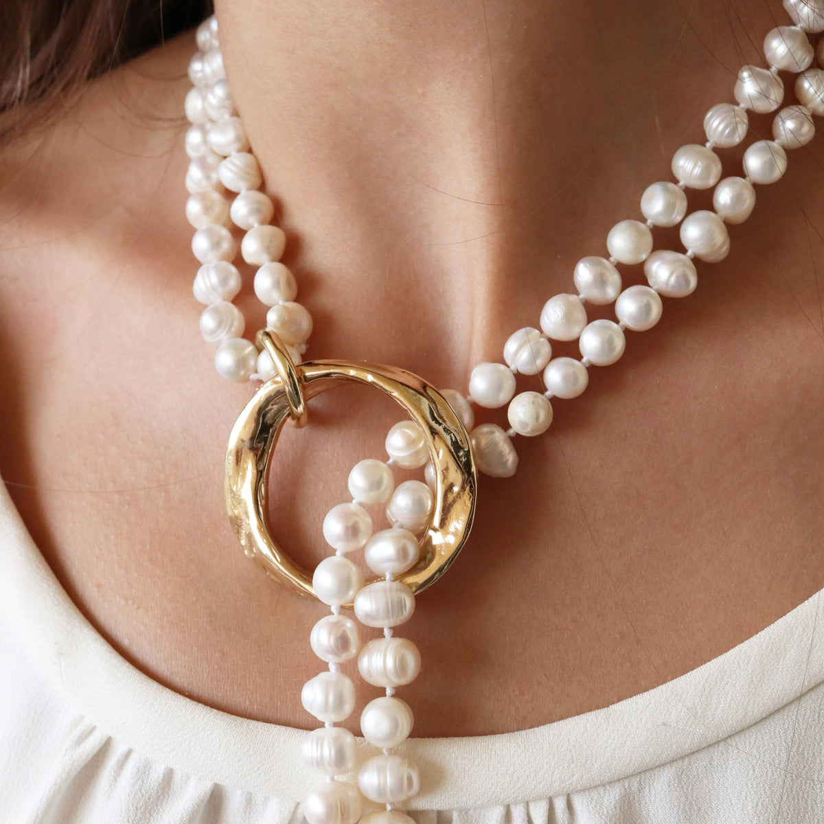 Collar de perlas blancas con anillo dorado, elegante y moderno, ideal para ocasiones especiales.