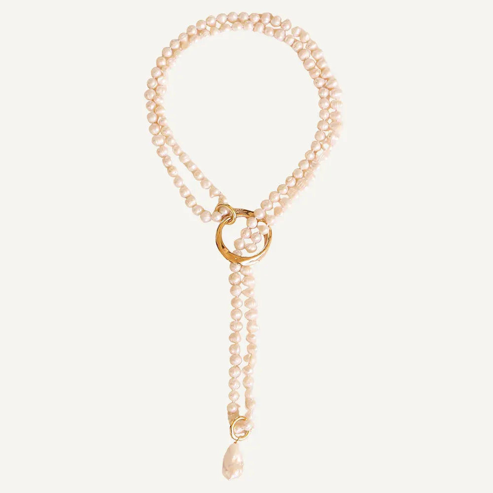 Collar de perlas blancas con anillo dorado y charm, estilo elegante y moderno.