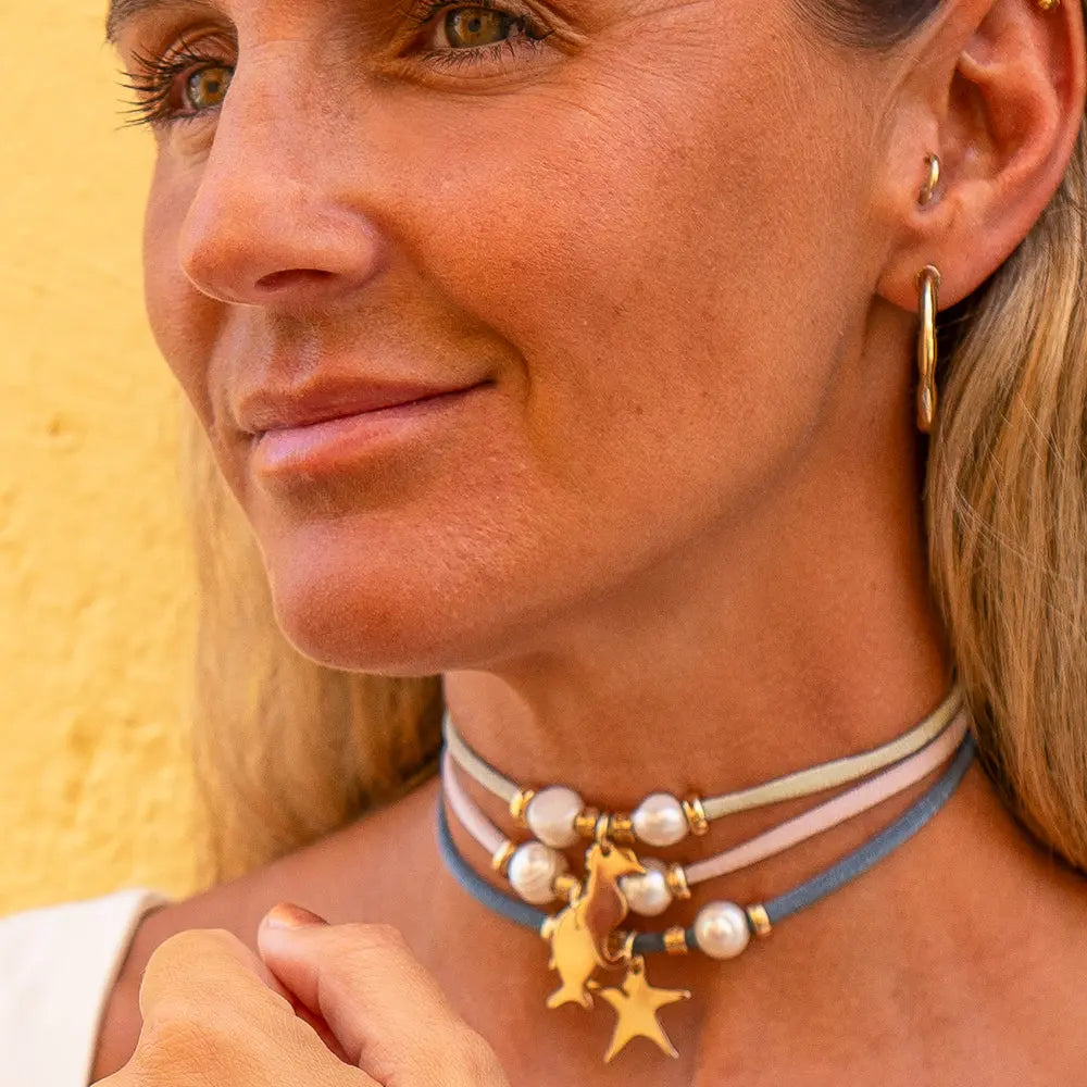 Collar de perlas y cintas azul y nude con charm dorado de unicornio, estilo bohemio y elegante.