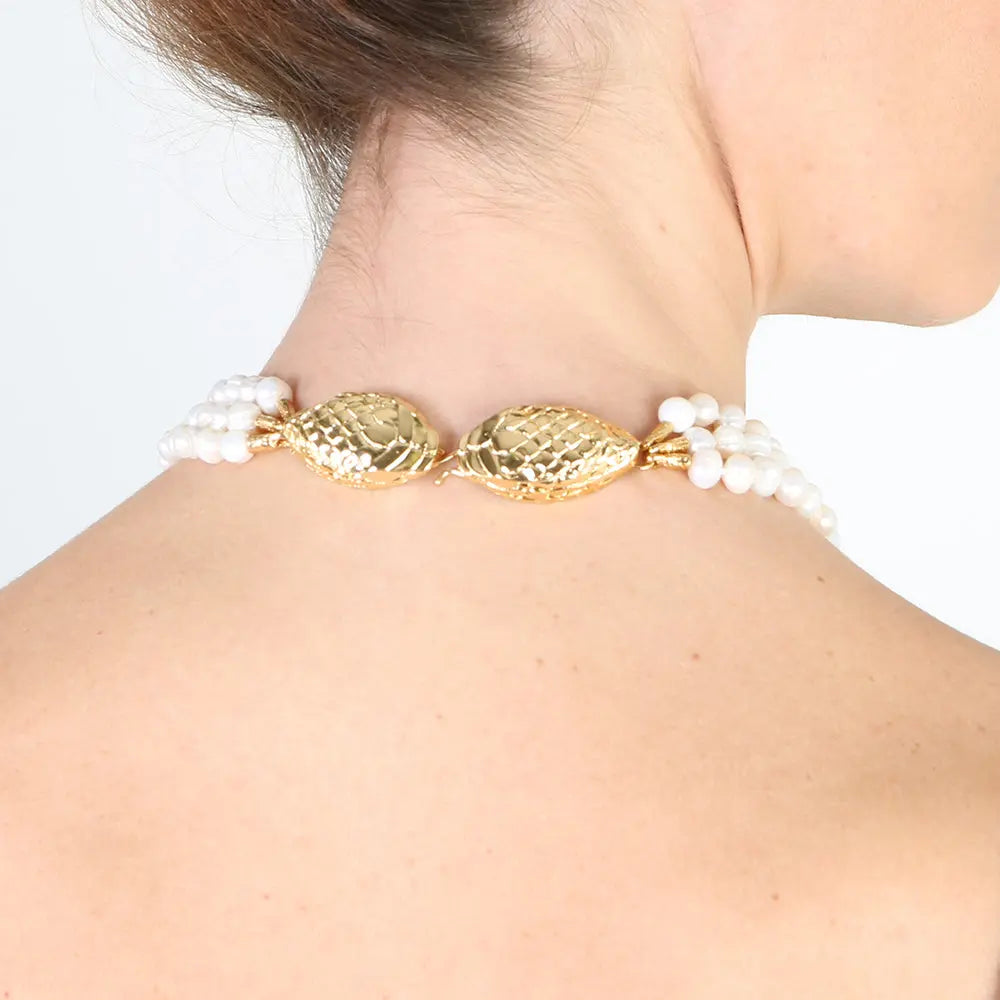 Collar elegante de perlas blancas con detalles dorados en forma de pez, ideal para ocasiones especiales.