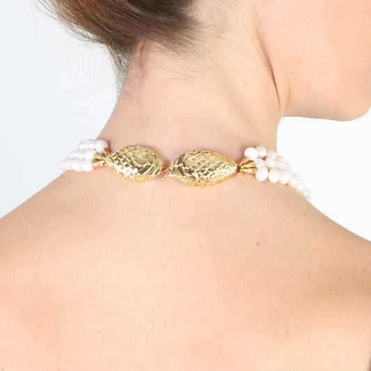 Collar elegante de perlas blancas con detalles dorados en forma de pez, ideal para ocasiones especiales.