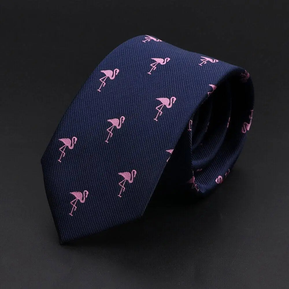 Corbata azul marino delgada con estampado de pequeños flamencos rosas, diseño elegante y moderno en tela texturizada.