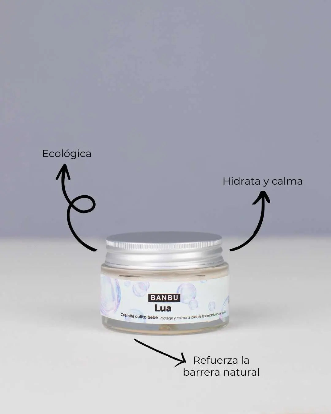 Tarro de crema LUA de Banbu con tapa metálica. Etiqueta con burbujas. Flechas indican beneficios: ecológica y calmante.