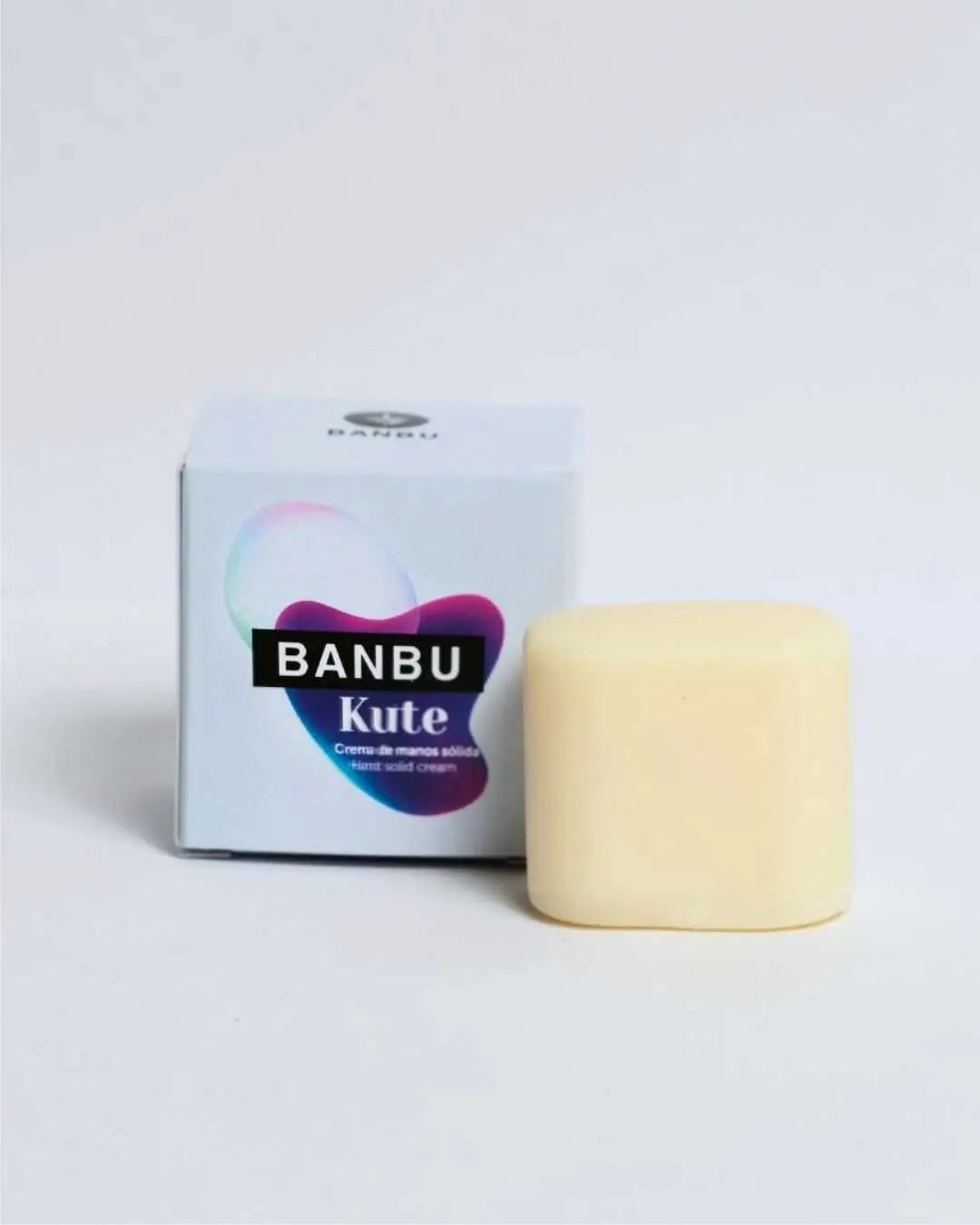 Crema de manos sólida Banbu Kute: pastilla amarillenta junto a su caja de cartón blanca con diseño degradado.